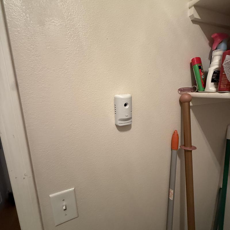 Carbon monoxide detector mounted on beige wall