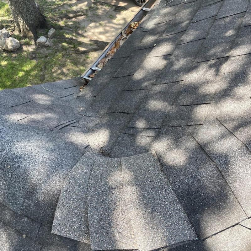 Asphalt shingle roof damaged section near gutter