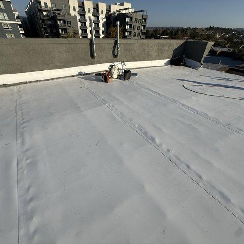 Flat roof membrane installation on commercial building roof Flat roof membrane installation on commercial building roof