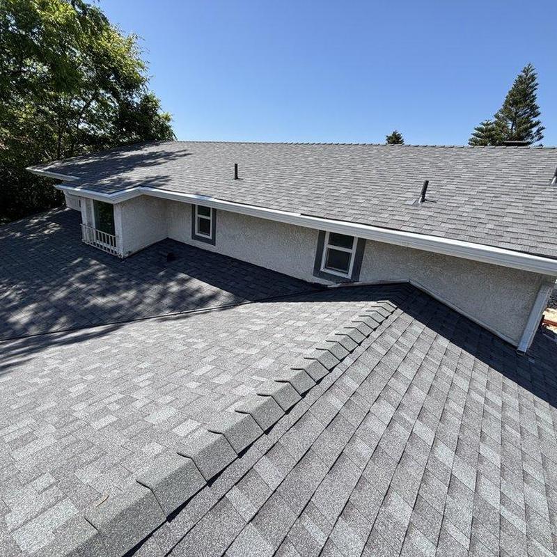 Shingle roof installation on residential home under clear sky Shingle roof installation on residential home under clear sky