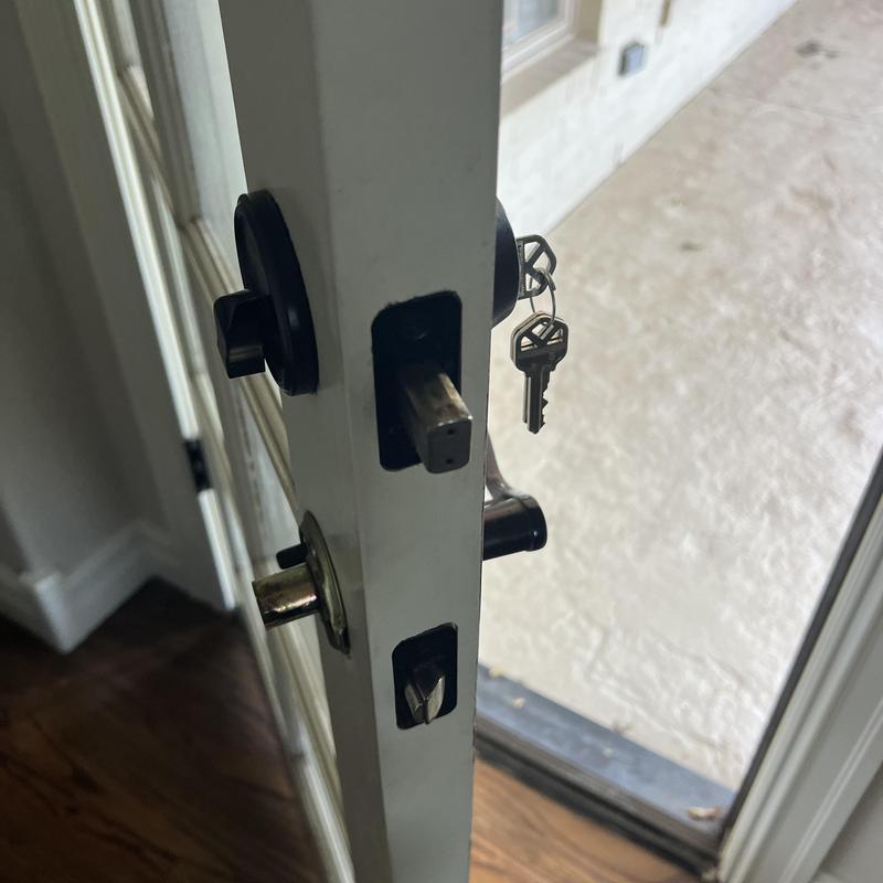 Deadbolt lock with key inserted in white door