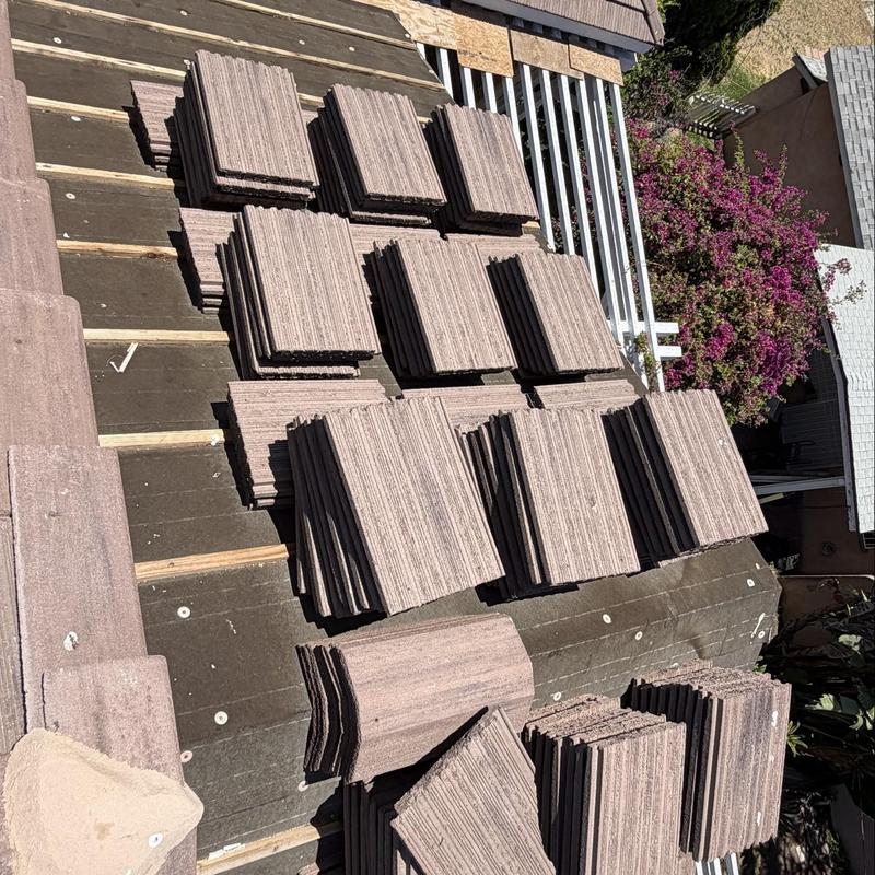 Flat roof tiles stacked on residential roof surface Flat roof tiles stacked on residential roof surface