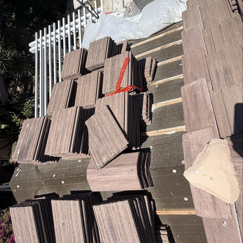 Flat roof tiles stacked on roof deck for installation Flat roof tiles stacked on roof deck for installation