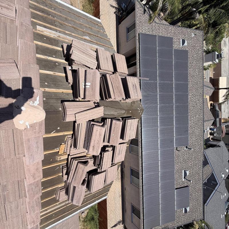 Flat roof tiles stacked for installation on stripped roof Flat roof tiles stacked for installation on stripped roof