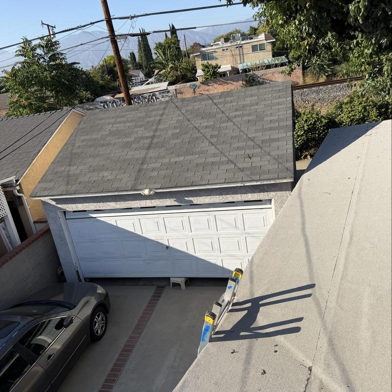 Shingle roof inspection over detached garage driveway Shingle roof inspection over detached garage driveway