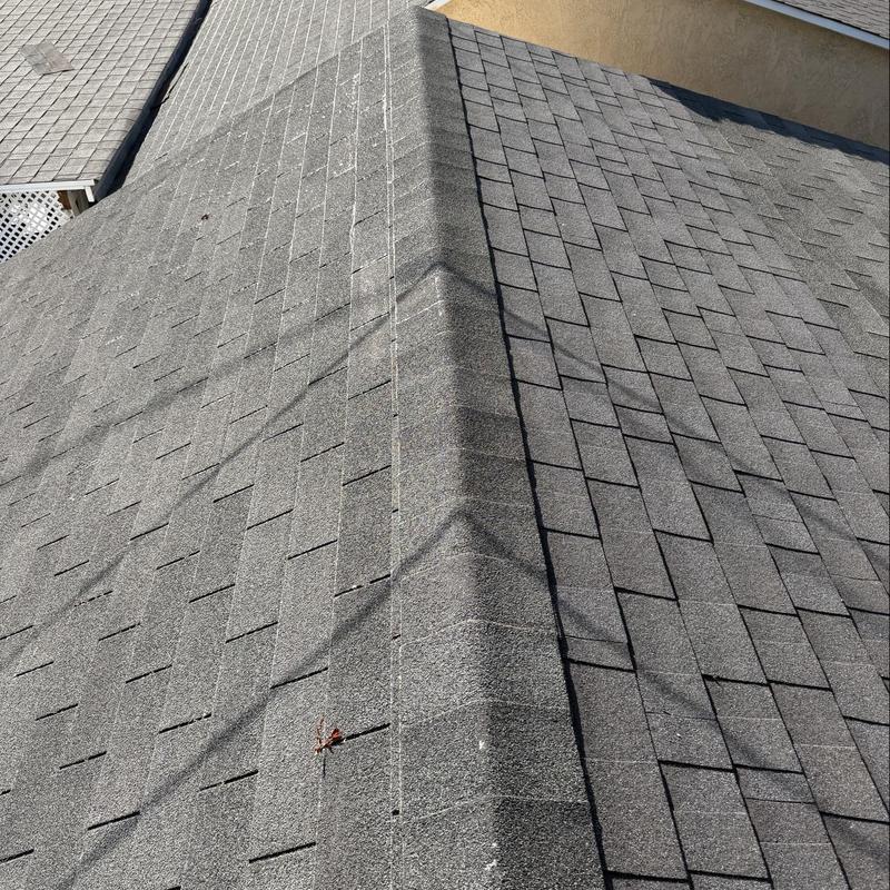 Asphalt shingle roof ridge with minor debris Asphalt shingle roof ridge with minor debris