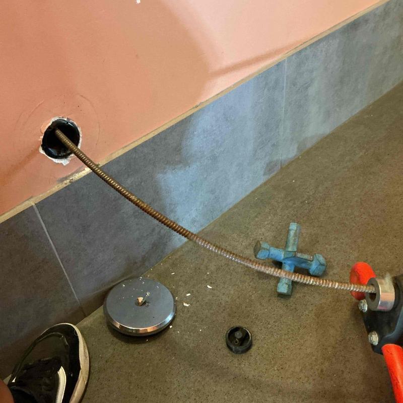 Bathroom sink cleanout with plumbing snake tool