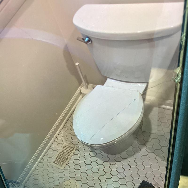 Elongated ADA toilet installed and sealed in bathroom