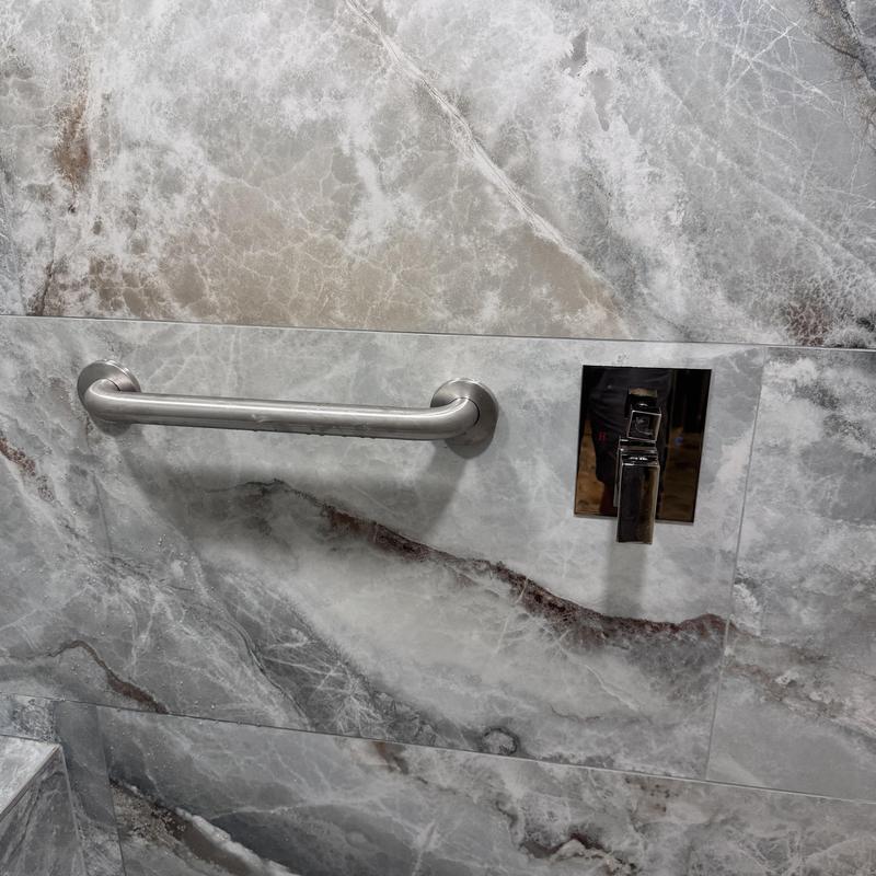 Shower grab bar and faucet on marble wall Shower grab bar and faucet on marble wall