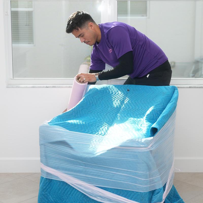 Moving blanket and plastic wrap securing furniture for move Moving blanket and plastic wrap securing furniture for move