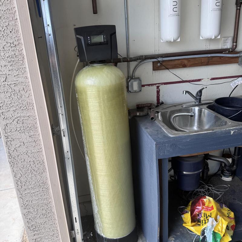 Water softener tank beside utility sink in garage Water softener tank beside utility sink in garage