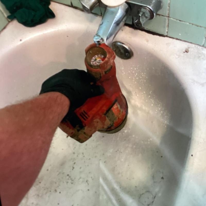 Bathtub drain with plumbing auger tool in use Bathtub drain with plumbing auger tool in use