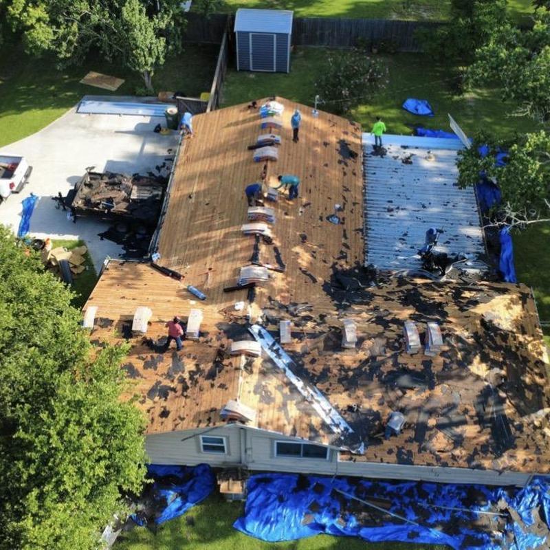 Residential roof decking with roofing material removal in progress