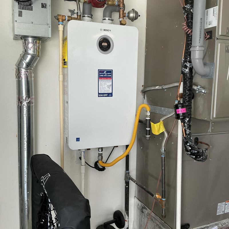 Tankless water heater with plumbing connections and venting