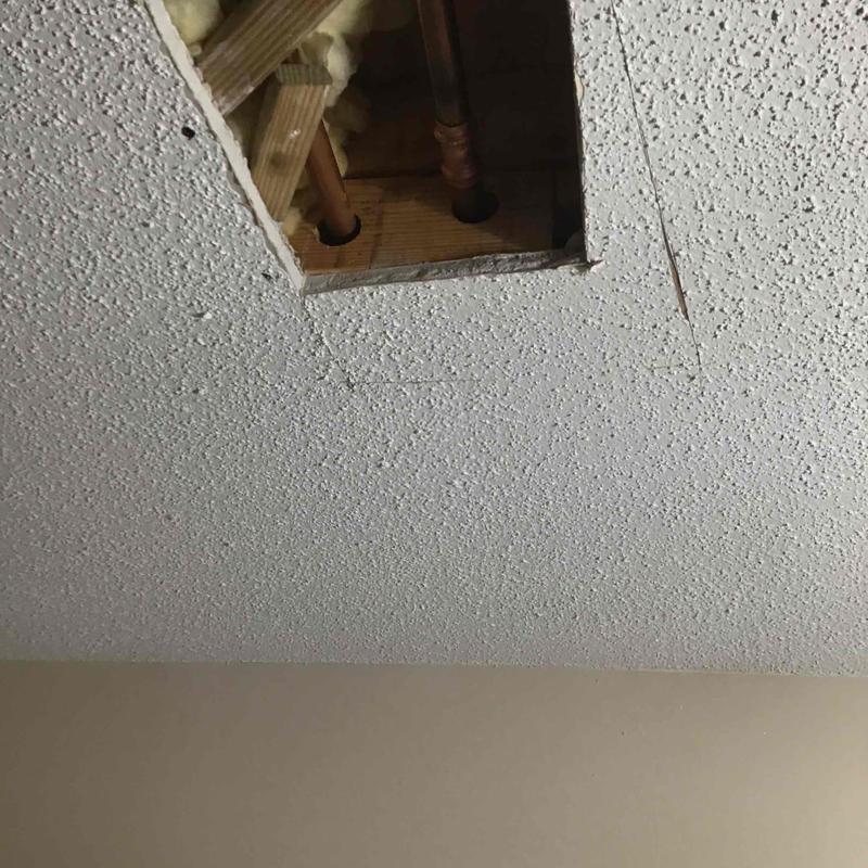 Copper pipes in ceiling with drywall removed for repair