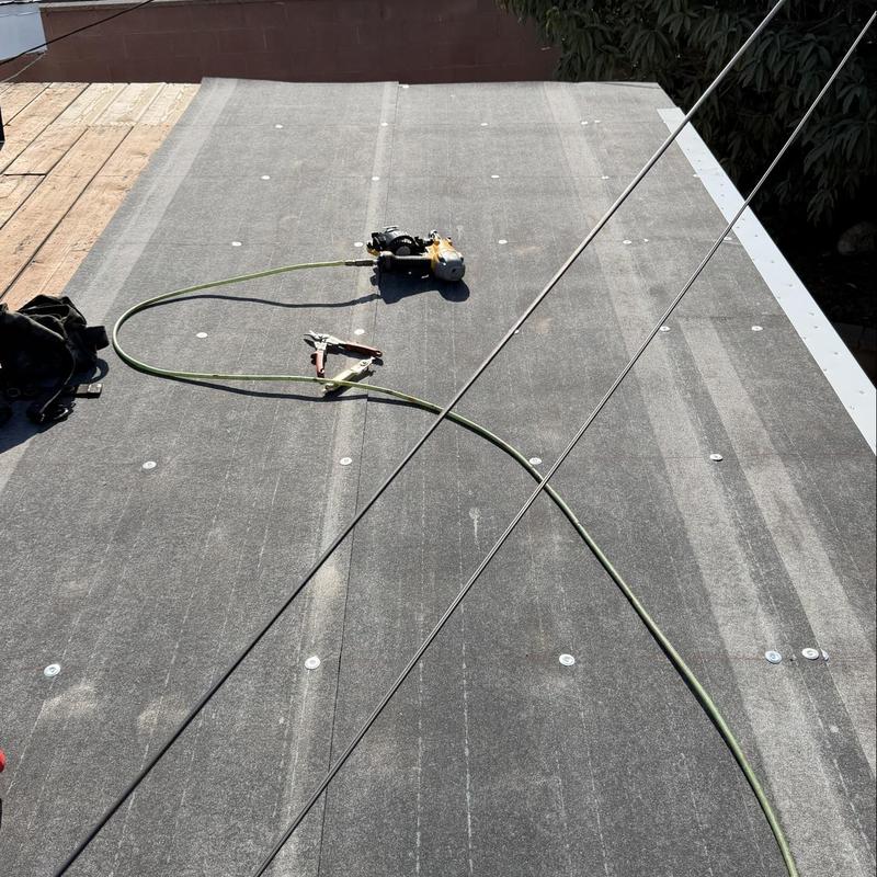 Roof underlayment installation with roofing tools on top Roof underlayment installation with roofing tools on top