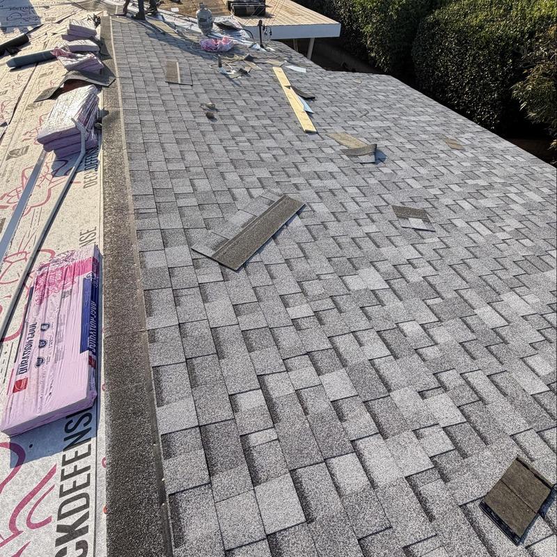 Shingle roof installation with materials and tools on deck Shingle roof installation with materials and tools on deck