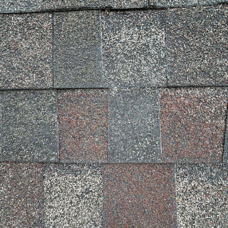 Asphalt shingle roof surface with visible hail damage