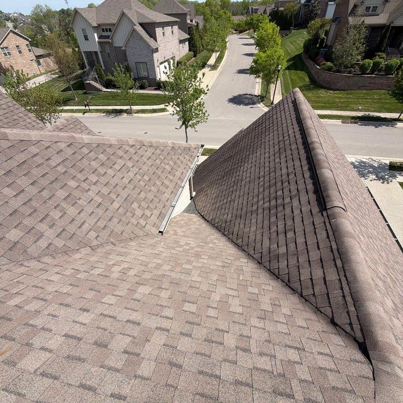 Asphalt shingle roof with multiple slopes and ridge caps