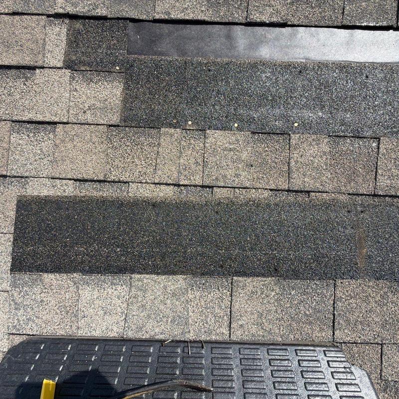 Asphalt roof shingles showing hail damage and repairs