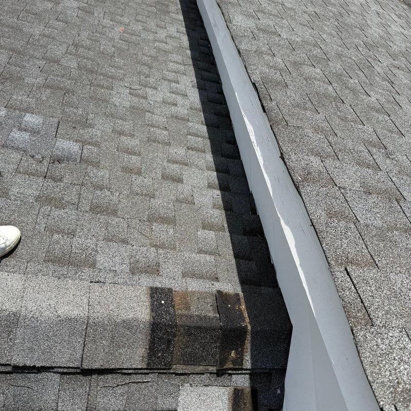 Asphalt shingles with hail damage near roof flashing