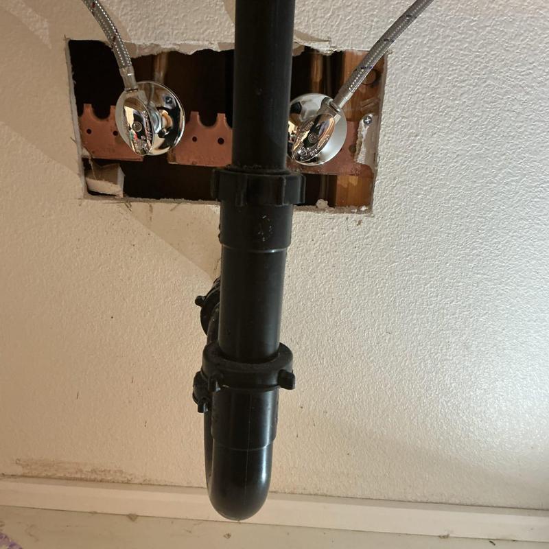 Copper angle stop valves behind drywall with drain pipe Copper angle stop valves behind drywall with drain pipe
