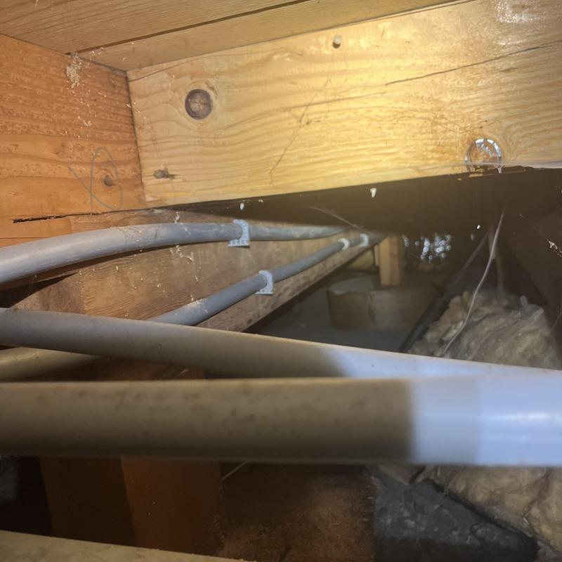 PEX water piping installation in crawlspace under floor joists PEX water piping installation in crawlspace under floor joists