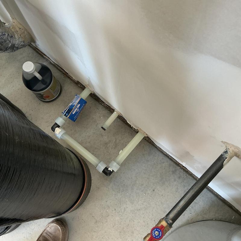 Water softener supply and drain pipe connections with cleaner bottle