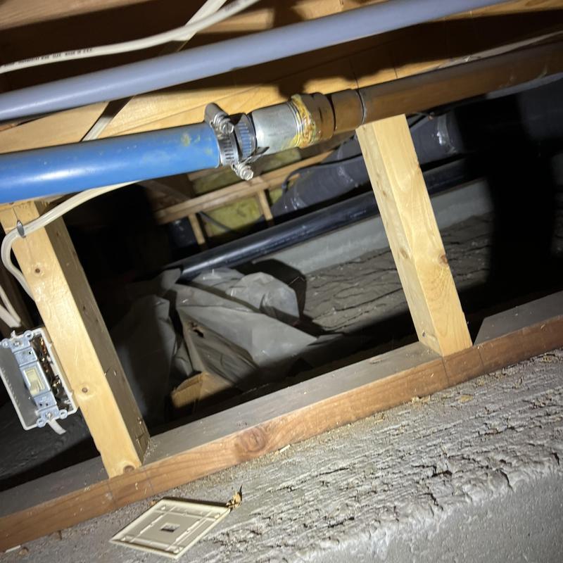 PEX water piping with metal coupling in crawl space