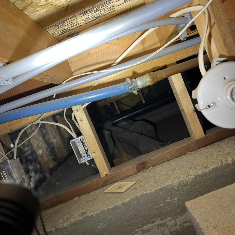 PEX water piping with metal fitting in crawl space