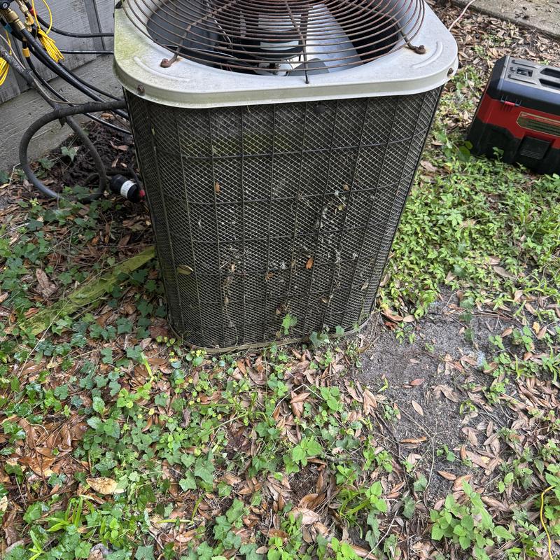 Condenser coil with dirty fins outdoors near wall