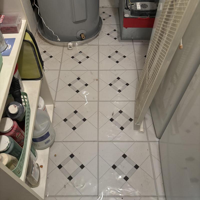 Water heater area with standing water on tile floor