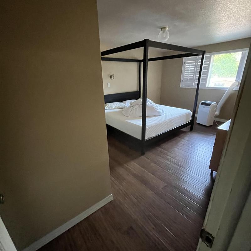 Portable air conditioner unit in bedroom with canopy bed