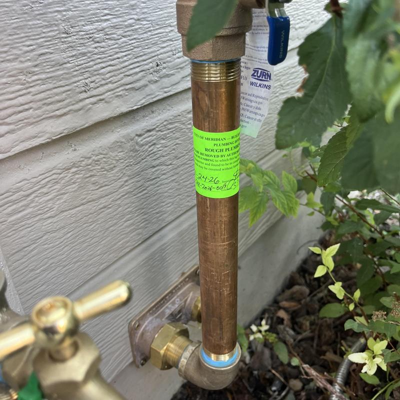 Backflow assembly with inspection tag outdoors Backflow assembly with inspection tag outdoors