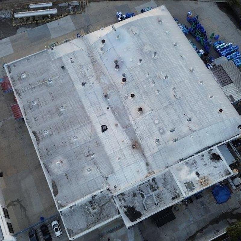 Commercial flat roof with ventilation pipes and damage signs Commercial flat roof with ventilation pipes and damage signs