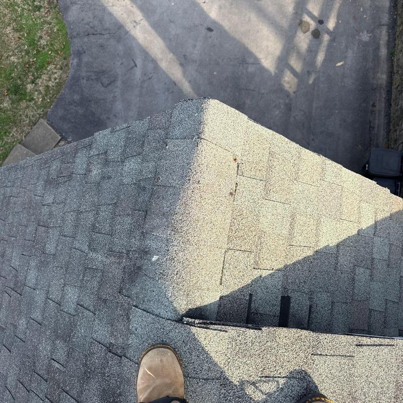Asphalt shingle roof with hail damage near ridge