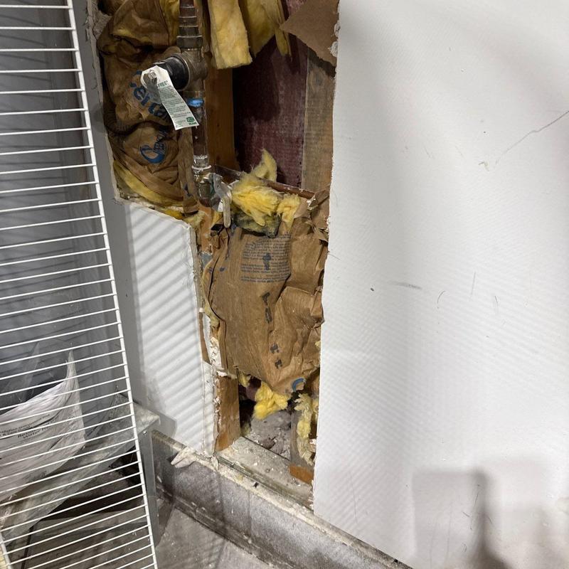 Water shutoff valve behind damaged drywall and insulation