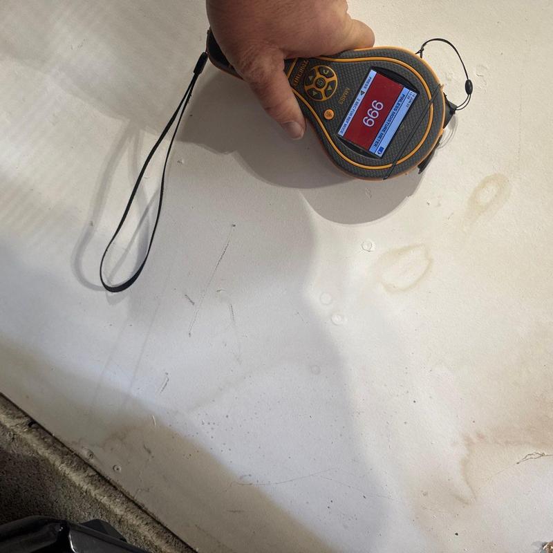 Roof moisture meter reading on water-damaged drywall panel