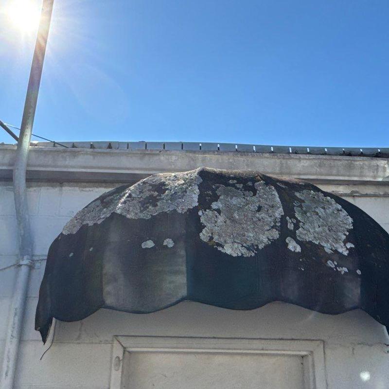 Fabric awning with extensive weather damage and wear