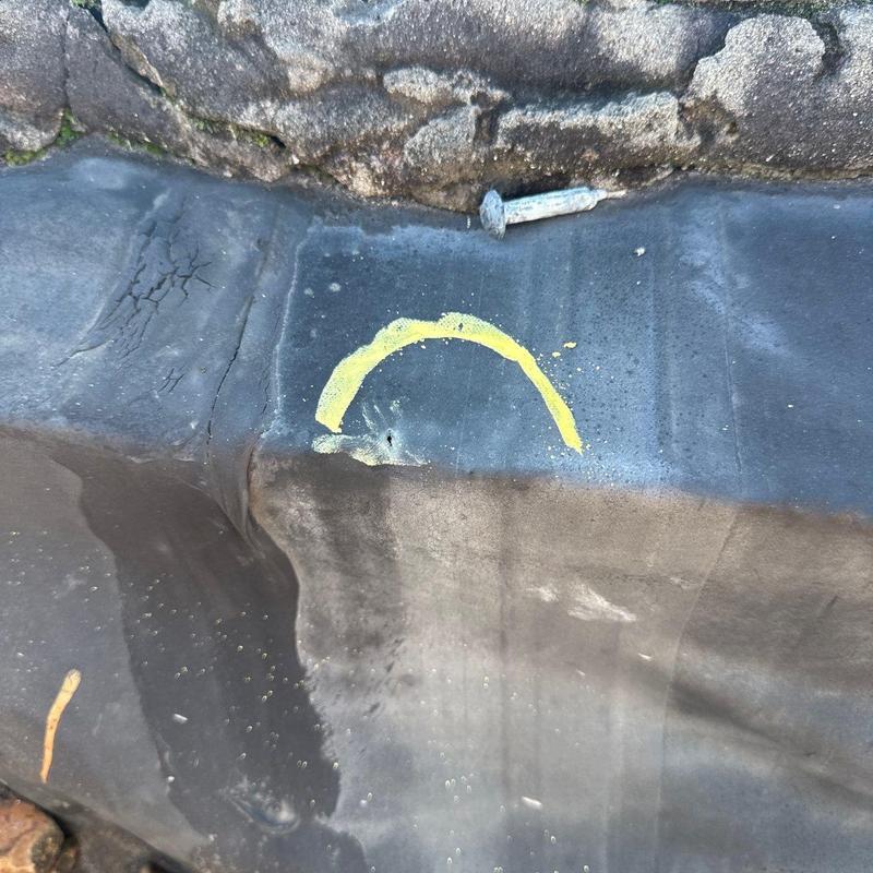 Commercial roof flashing with hail damage marked