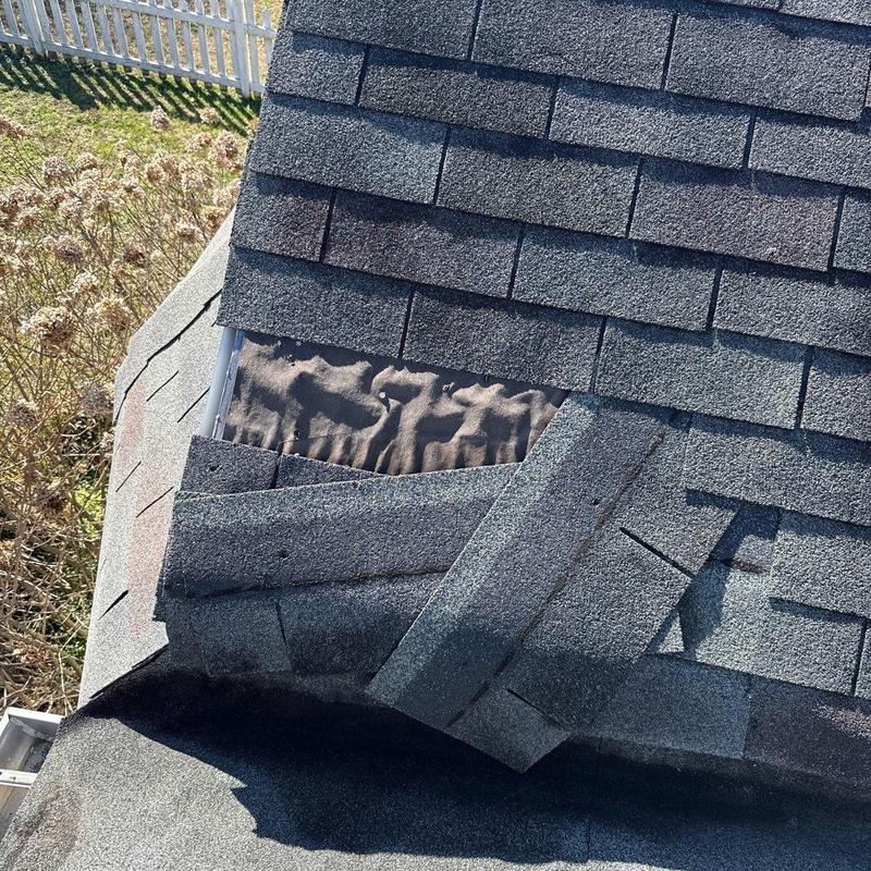 Damaged roof shingles and exposed underlayment detail