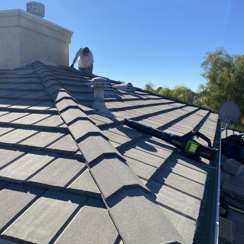 Tile roof with technician inspecting damage in California Tile roof with technician inspecting damage in California