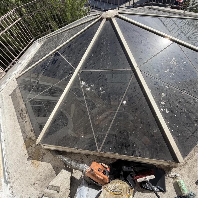 Skylight glass panels with cleaning tools on roof edge Skylight glass panels with cleaning tools on roof edge