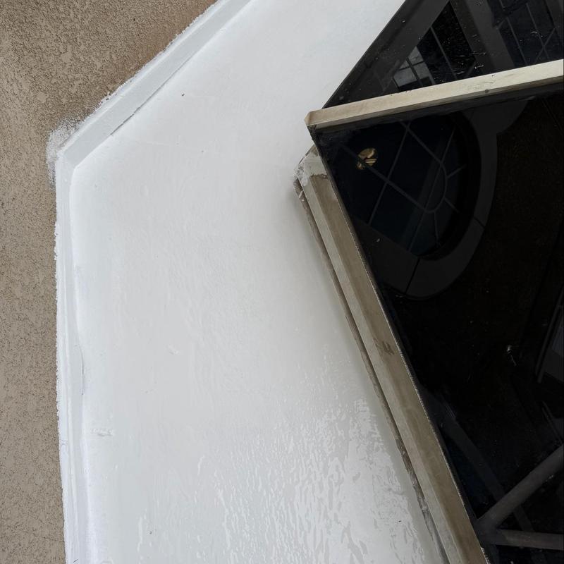 Silicone coating on flat roof around window frame Silicone coating on flat roof around window frame
