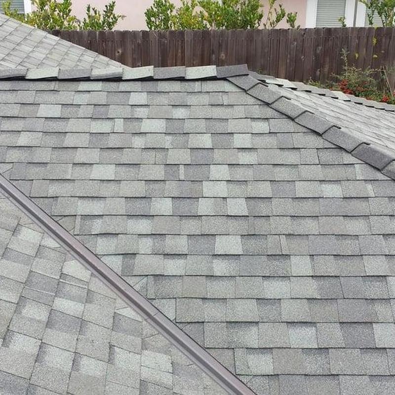 Gray asphalt shingle roof with ridge cap installation Gray asphalt shingle roof with ridge cap installation