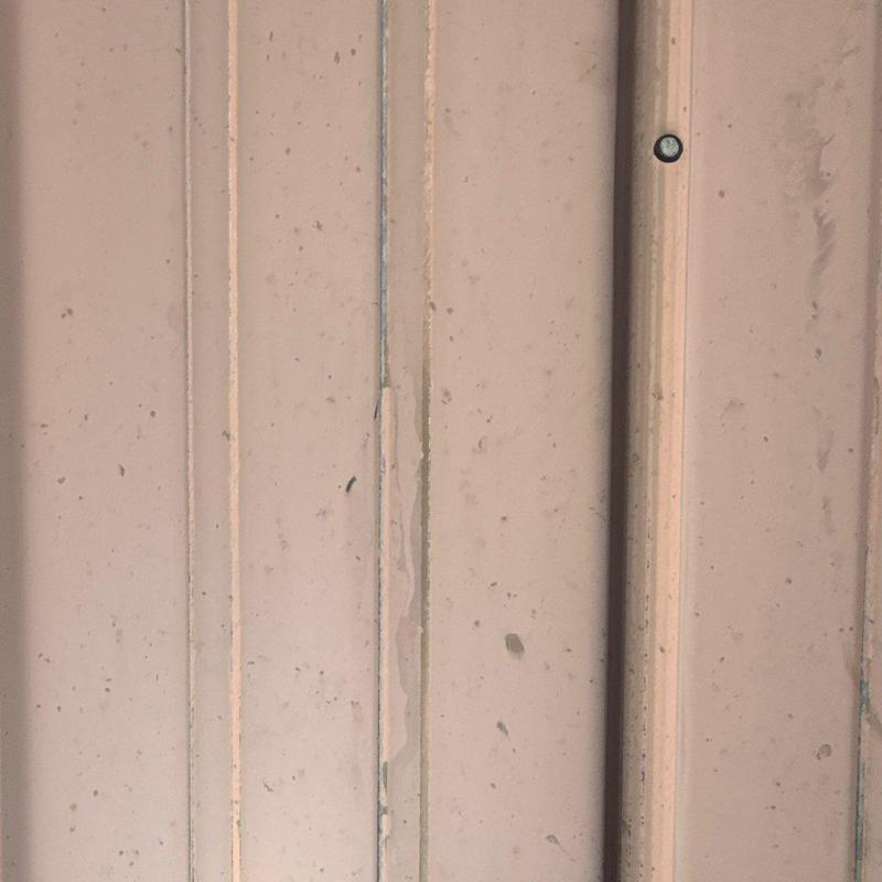 Metal roofing panel with hail impact marks