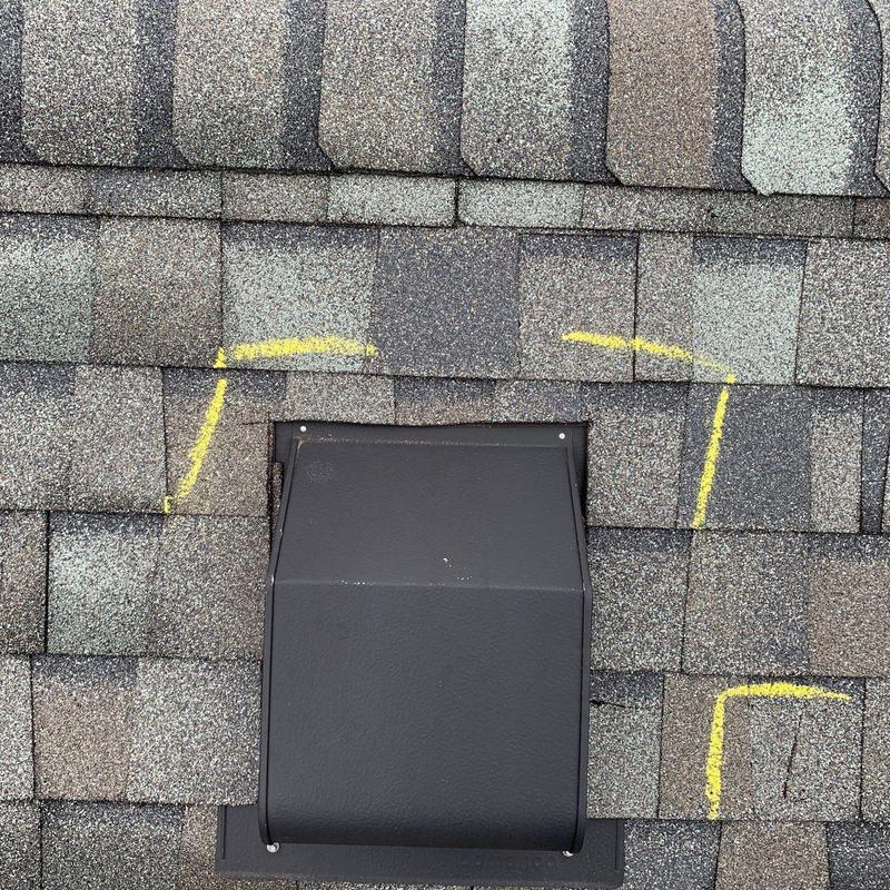 Roof shingles with yellow markings around vent flashing