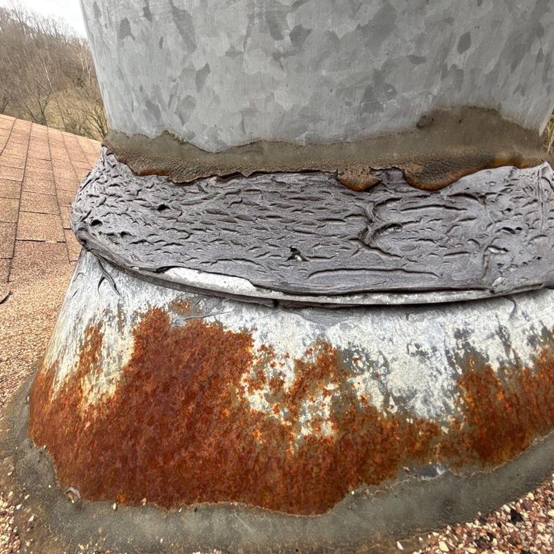 Metal chimney flashing with rust and sealant deterioration