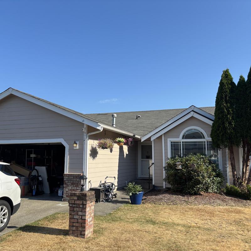 Asphalt shingle roof on beige residential house exterior Asphalt shingle roof on beige residential house exterior