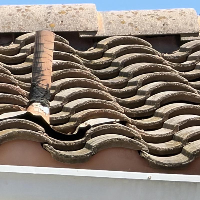 Tile roof with damaged and displaced tiles near vent pipe Tile roof with damaged and displaced tiles near vent pipe